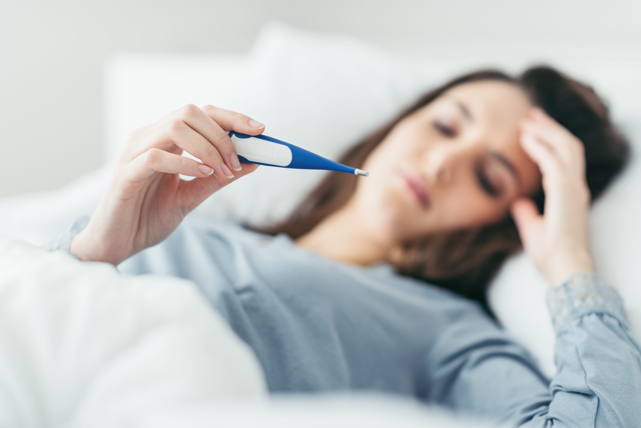 Woman reading thermometer-Acanthamoeba Woman lying in bed reading thermometer