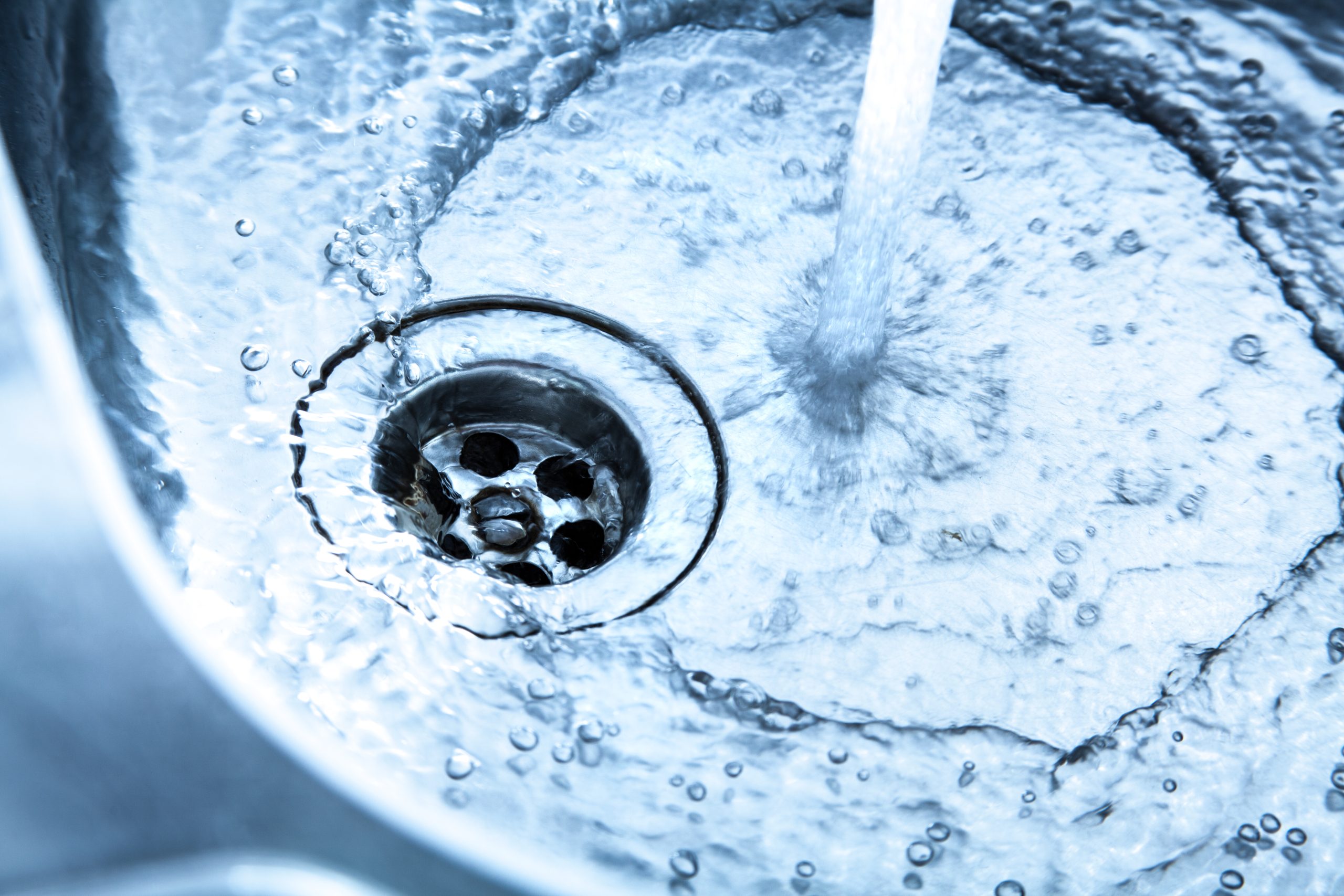 Water and Drain Image Water from faucet swirling down a drain