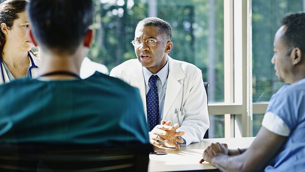 Doctors leading discussion in medical team meeting in conference room in hospital
