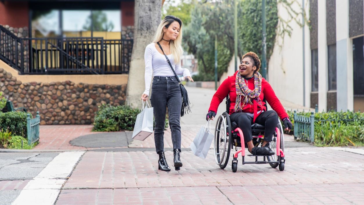 -- title missing -- Two women, one in a wheelchair, crossing the street at a safe place to do so.