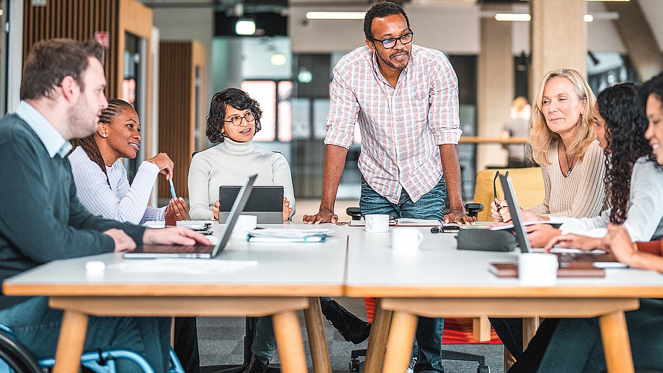 — title missing — Diverse group of people working at a table.