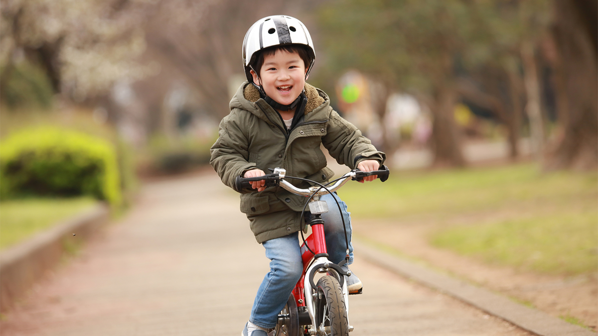 Risk of injuries The boy is riding his bike happily.