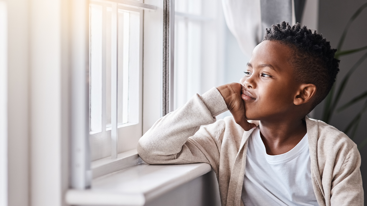 — title missing — A young boy is looking out the window.