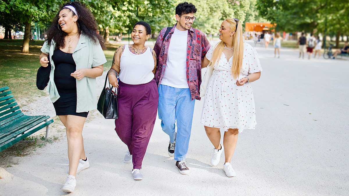 Group walking in park Group of four friends walking in a park.