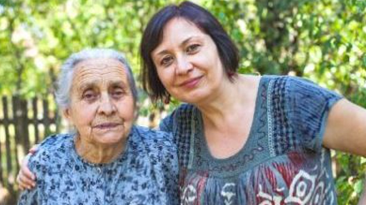 Older Woman and Daughter An older Hispanic woman with gray hair (on left), arm in arm with and a middle-aged Hispanic woman with short, black hair (on right).