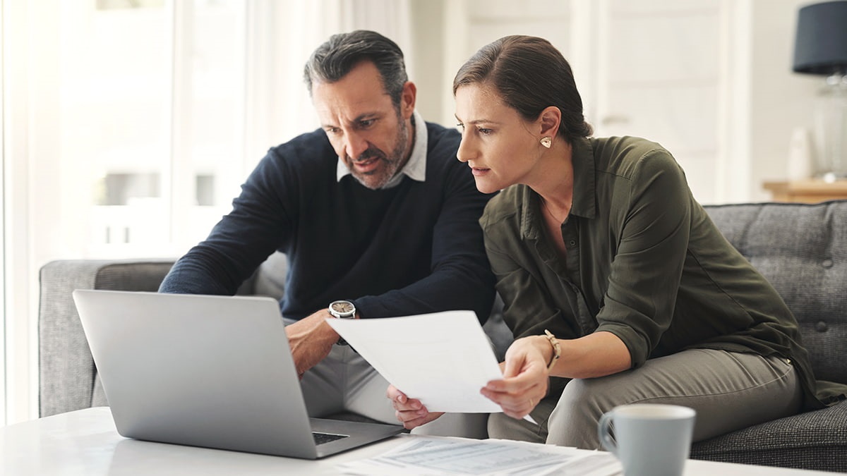 data couple sitting together and looking at data on laptop