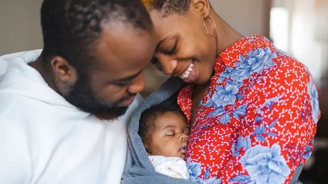 ART Success Rates parents holding sleeping infant
