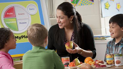teacher in class with students Teacher introducing foods to students in a classroom.