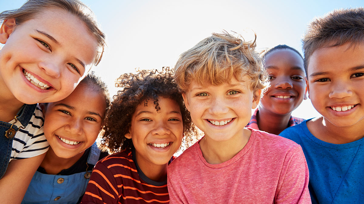 A group of diverse children gathered and smiling together.