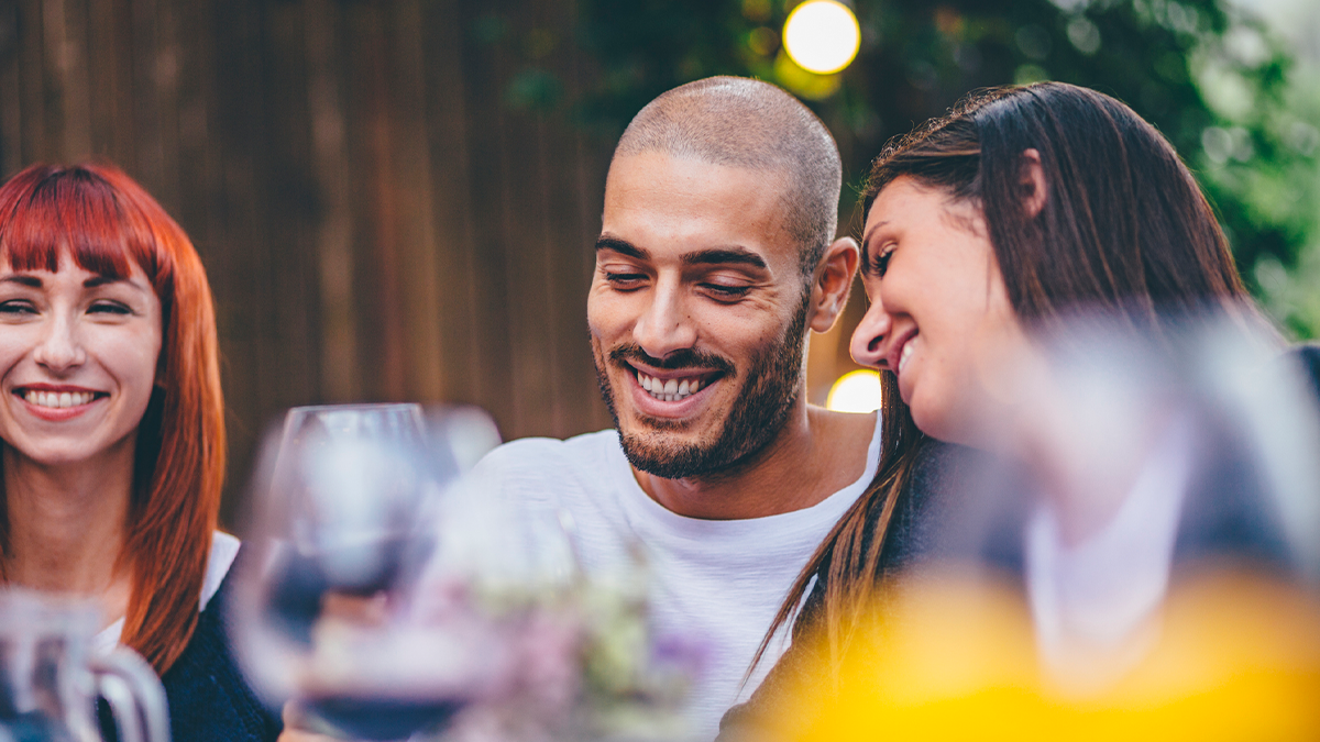 Three adults eating and smiling
