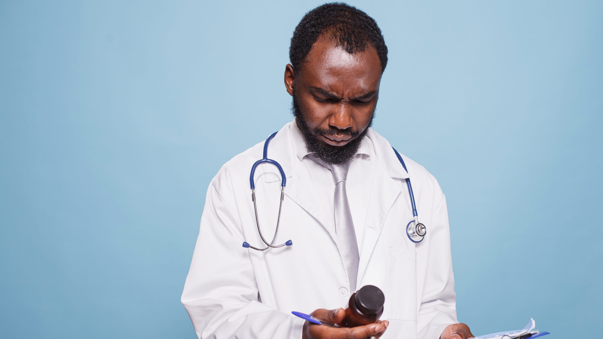 — title missing — Clinician looking at a prescription bottle.