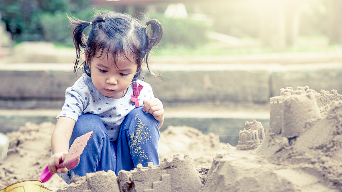 Young girl in sandbox Young girl playing in a sandbox.