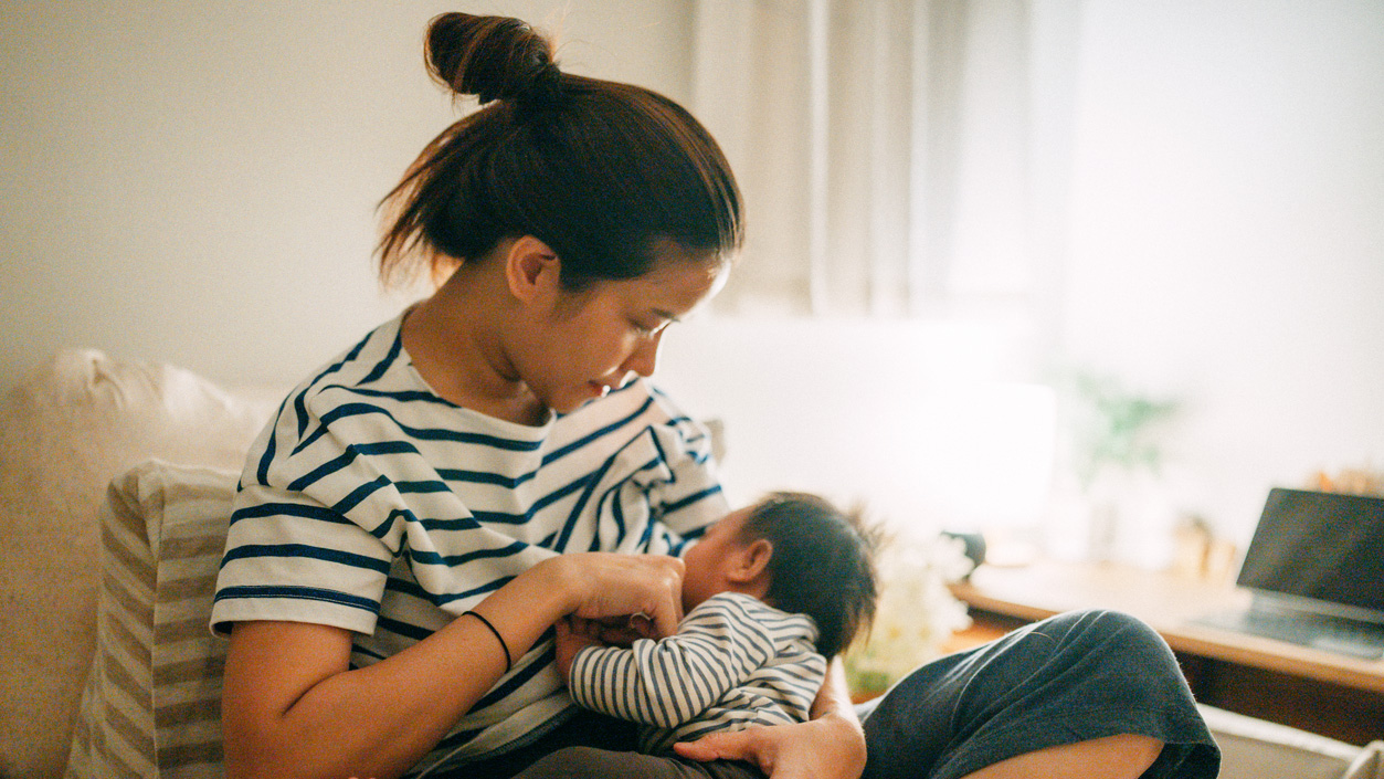 Mom breastfeeding baby A mom sits and breastfeeds her baby.