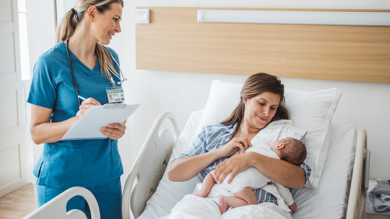 mPINC Scoring A nurse takes personal data from a mother and talks to her while she holds her newborn baby.