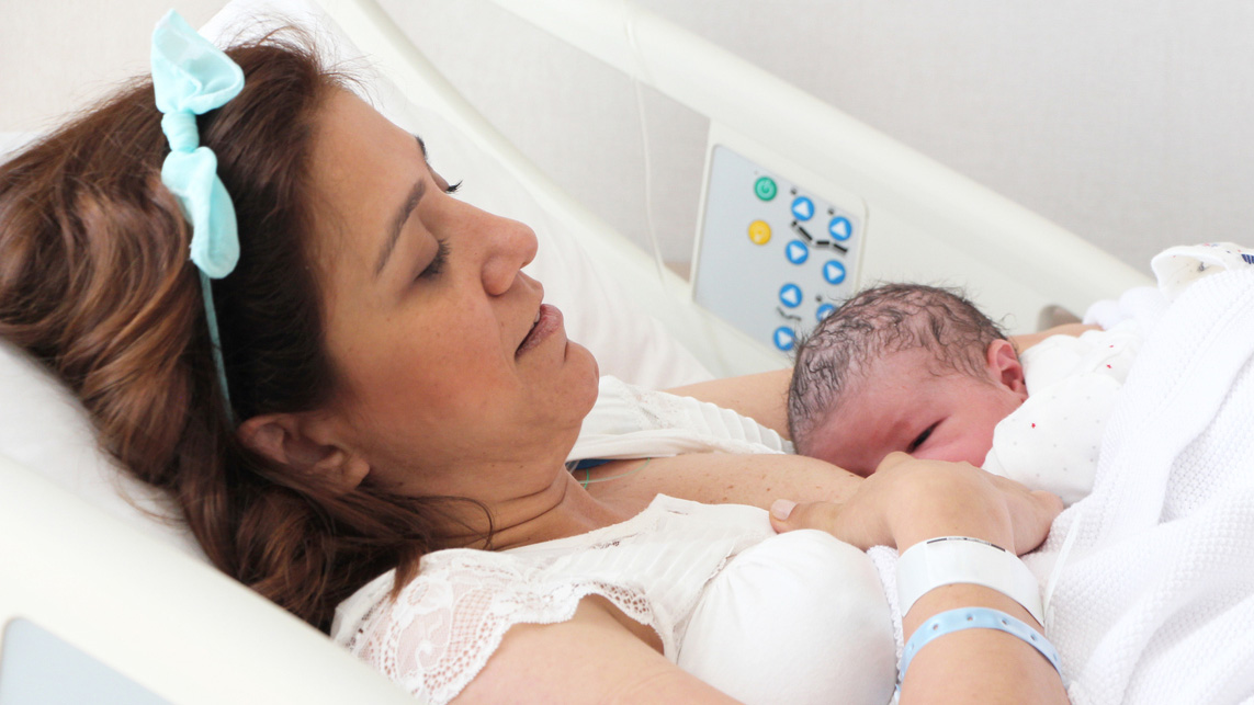 mPINC Step One breastfeeding mom A mother nursing her newborn in hospital bed.
