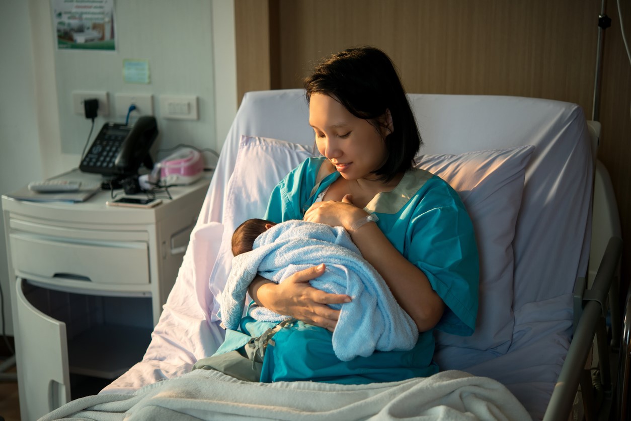 Mother breastfeeding in hospital Mother breastfeeding newborn baby in hospital setting.