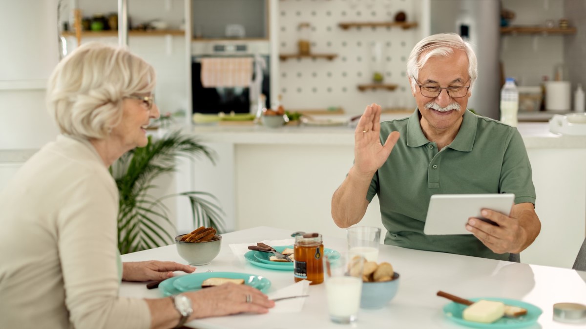 Couple Photo of a mature man making a video call over a digital tablet at home