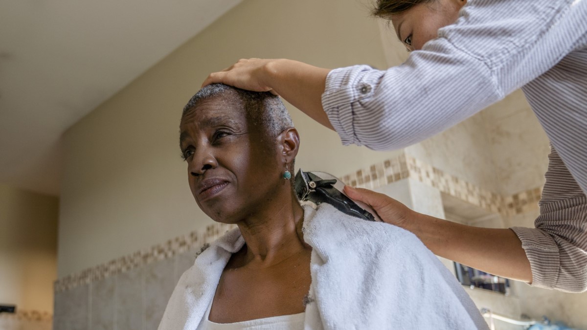 Shave a cancer survivor experiencing hair loss getting her hair shaved off
