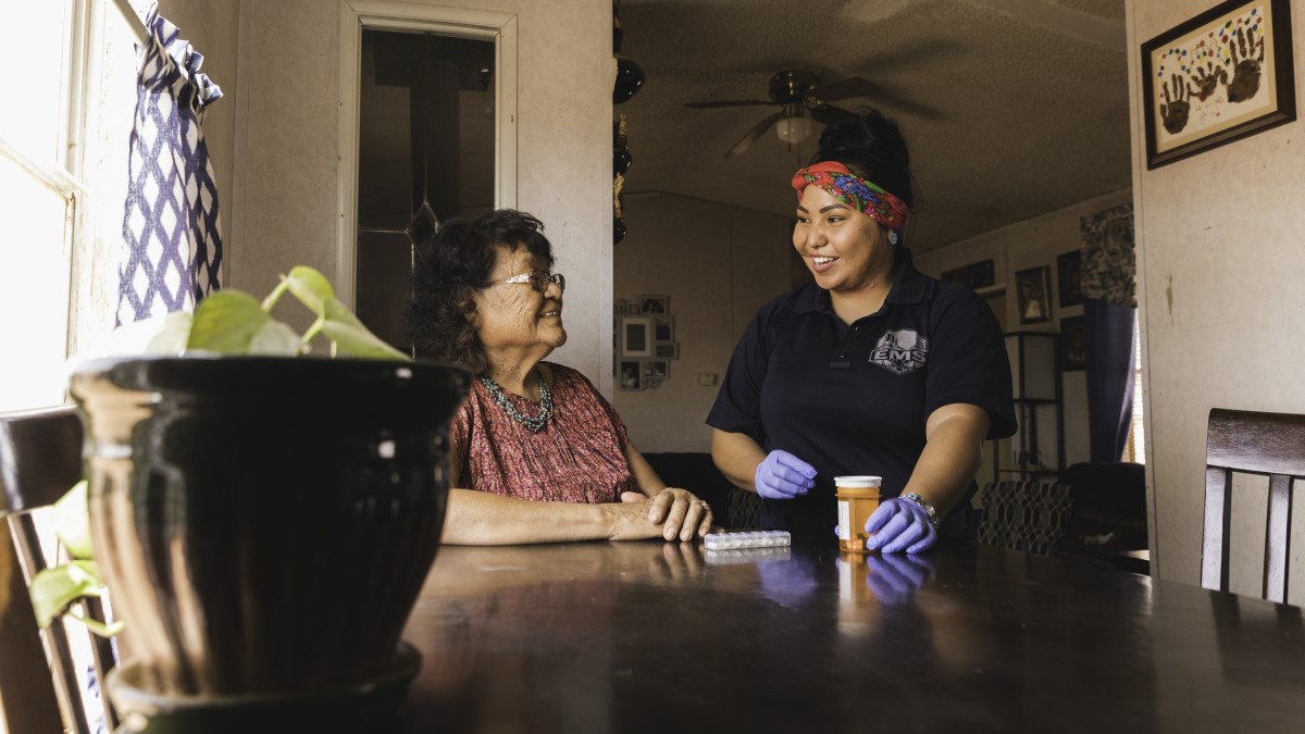 Navajo A community health worker helps a woman with her medication