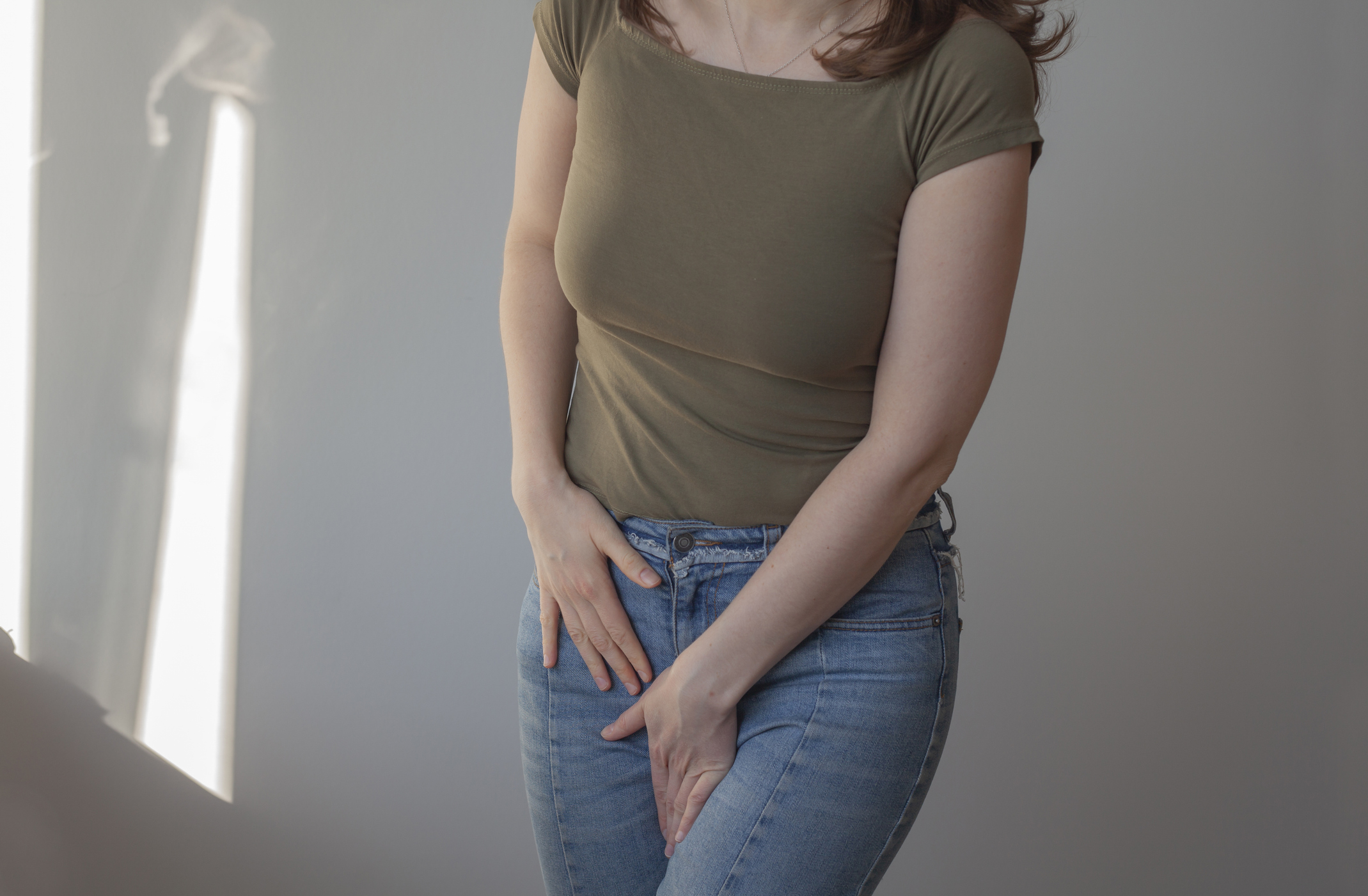 Vaginal candidiasis (yeast infections) are one of the most common fungal infections. A woman holding her pelvic area.