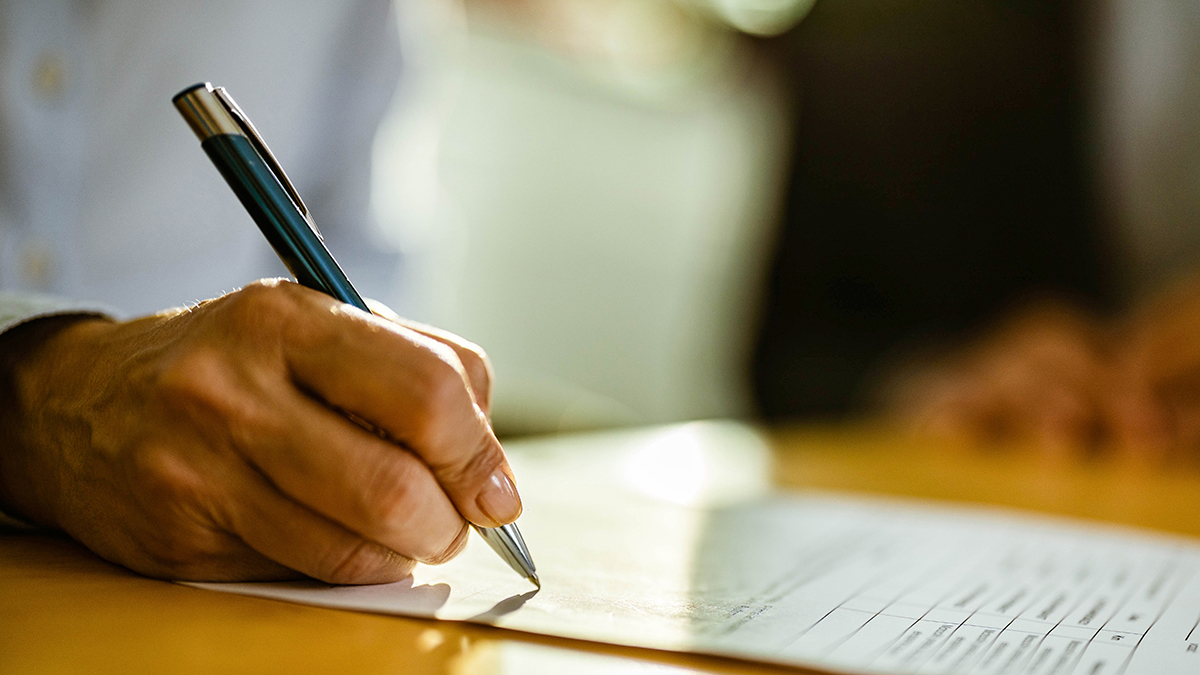 PAD state law fact sheet Person writing on form in pen