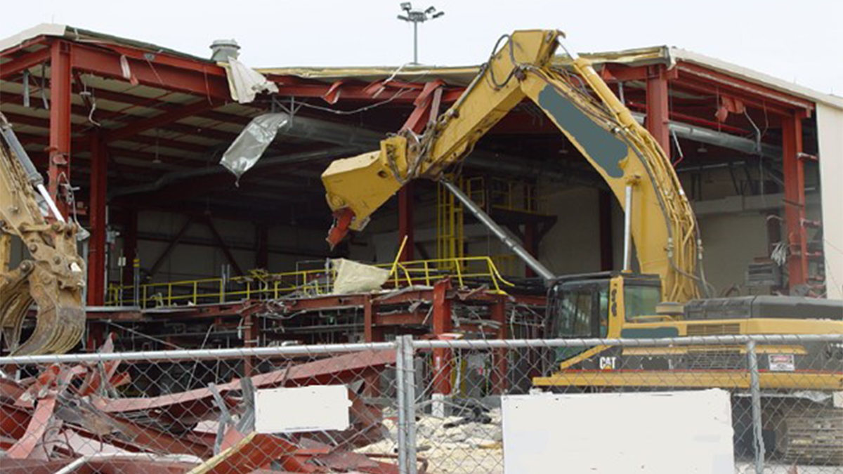 Remoted demolition of chemical agent destruction facility. A material handler taking apart the metal structure of a chemical agent destruction building.