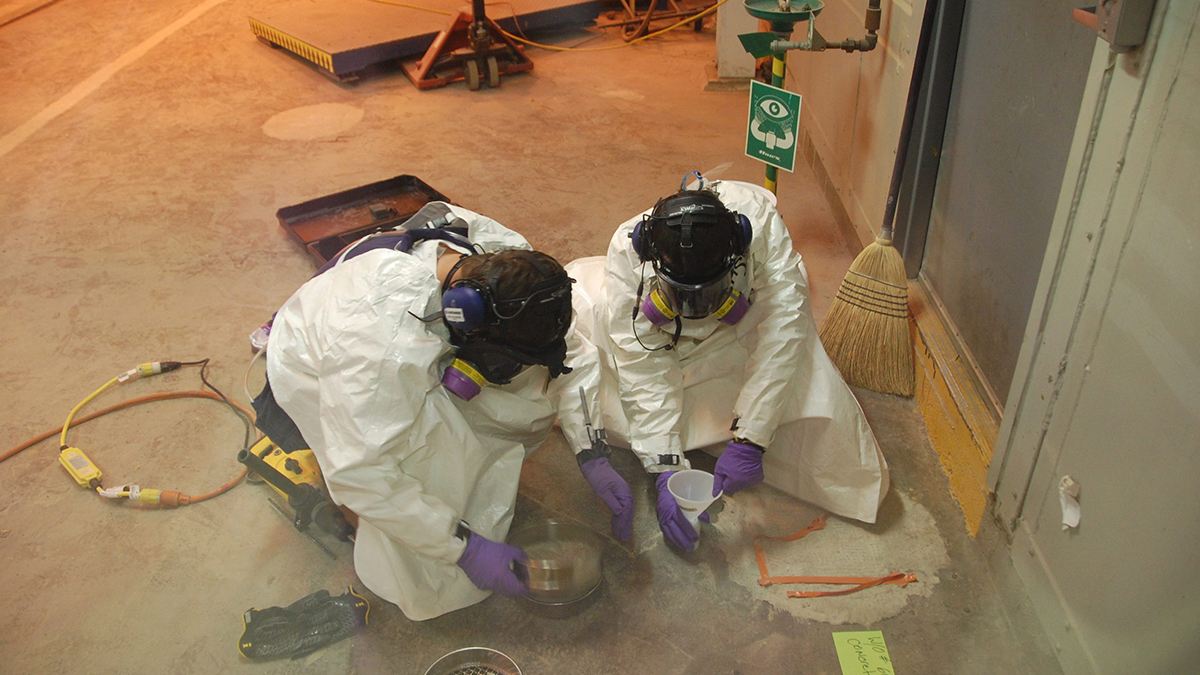Chemical workers taking concrete samples. Two chemical agent workers sampling the building concrete during closure.