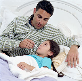 Sick child Father taking temperature of sick daughter in bed.