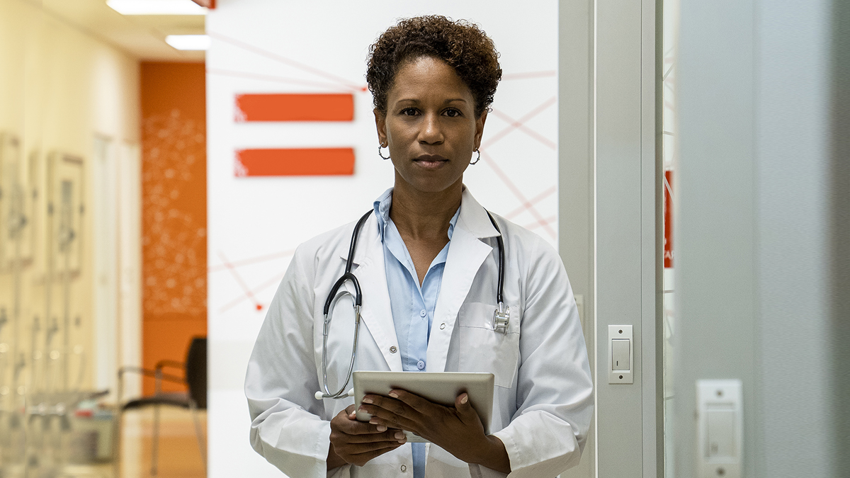 — title missing — A female doctor with a stethoscope around her neck.