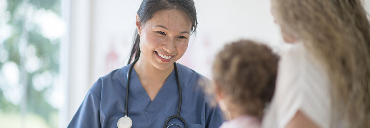 Health care provider talking to child and mother.