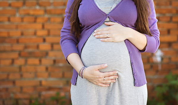 — title missing — Pregnant mother holding belly.