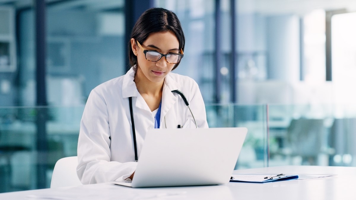 A doctor working on a laptop