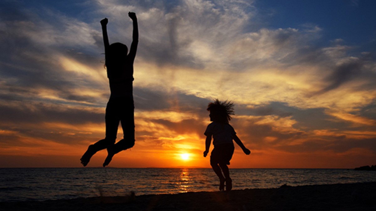 beach-sunset Happy young family have fun on beach and jump at sunset