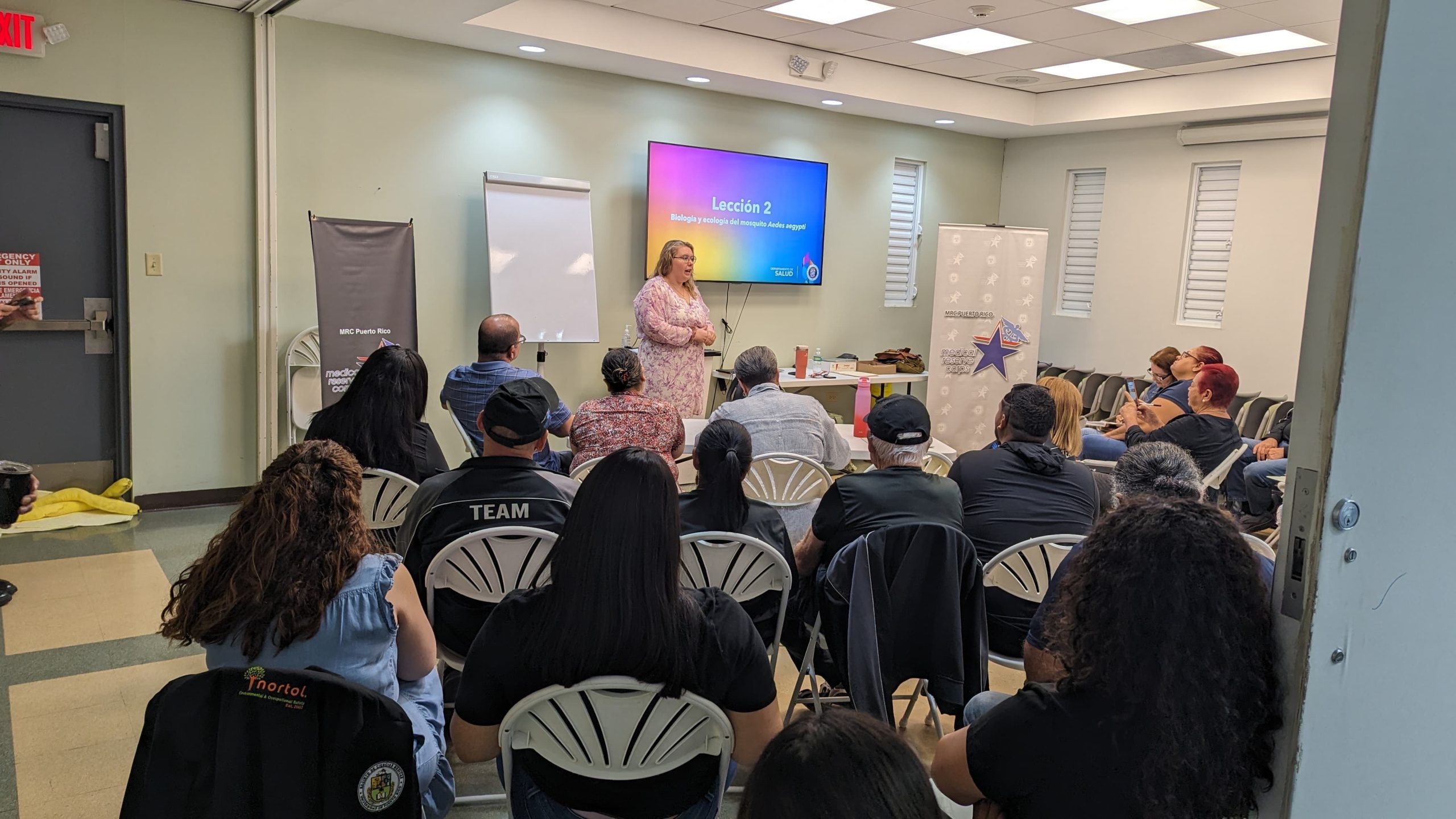 Medical Reserve Corp training A person presenting in front of a room of seated people.
