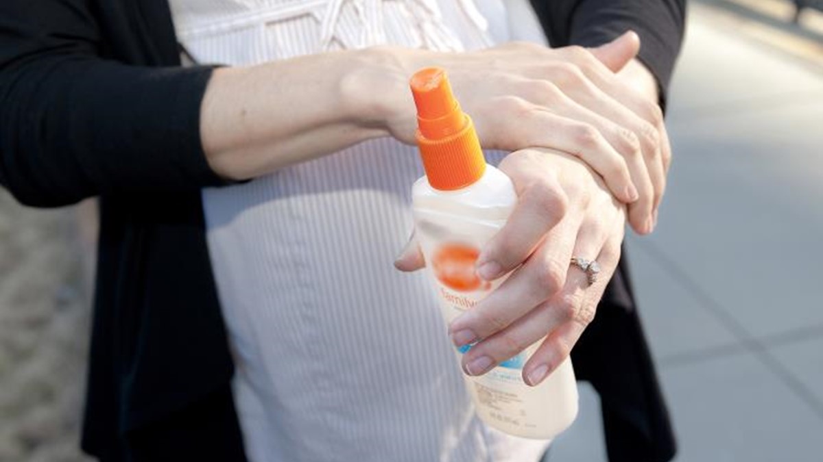 dengue during pregnancy thumbnail A pregnant woman applying insect repellent.