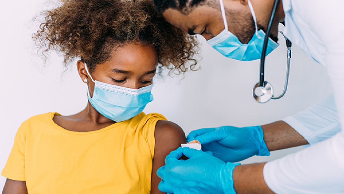 — title missing — Healthcare provider applying a bandage to a child's arm.