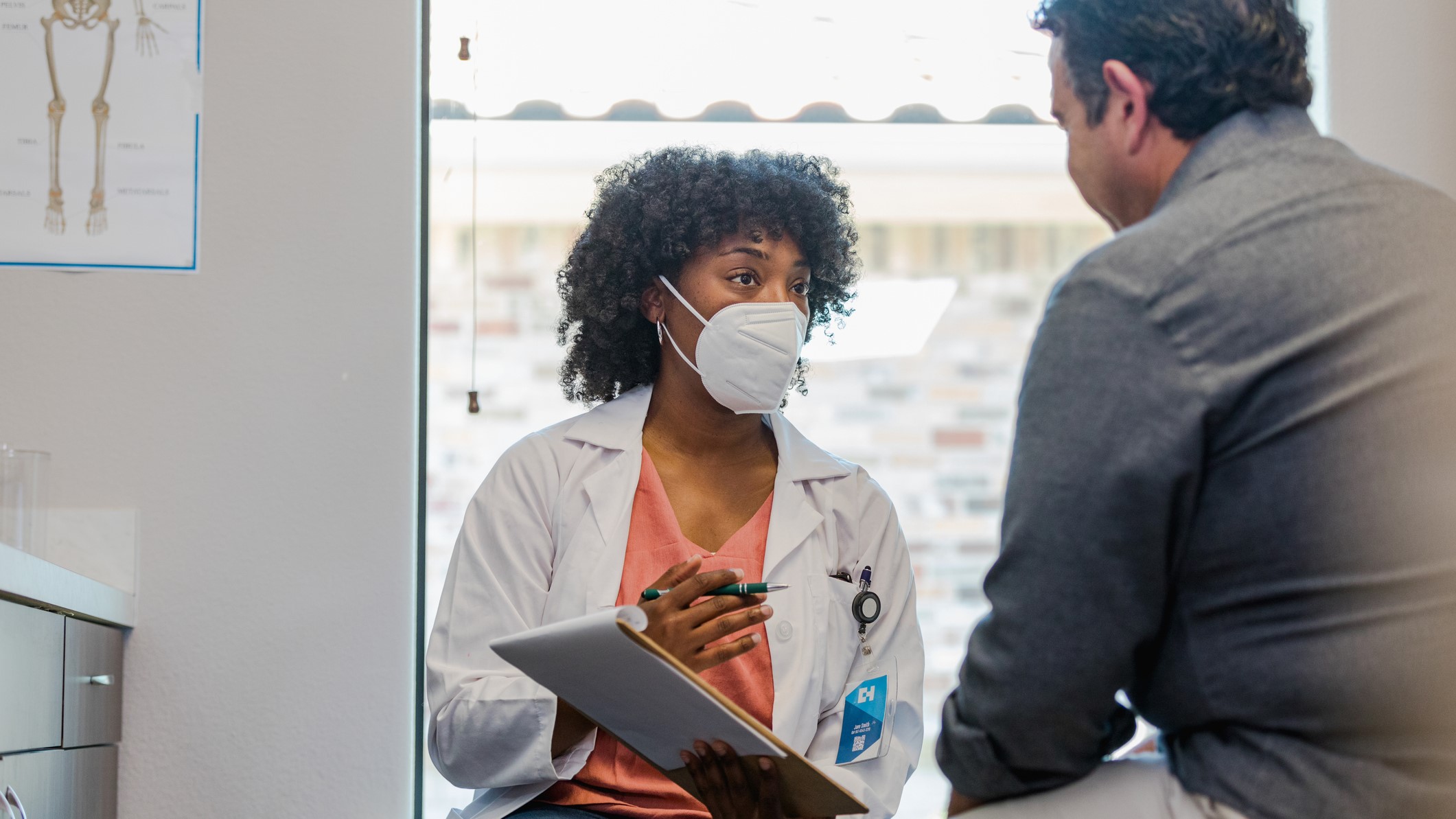 — title missing — A doctor wearing a mask talking to a patient