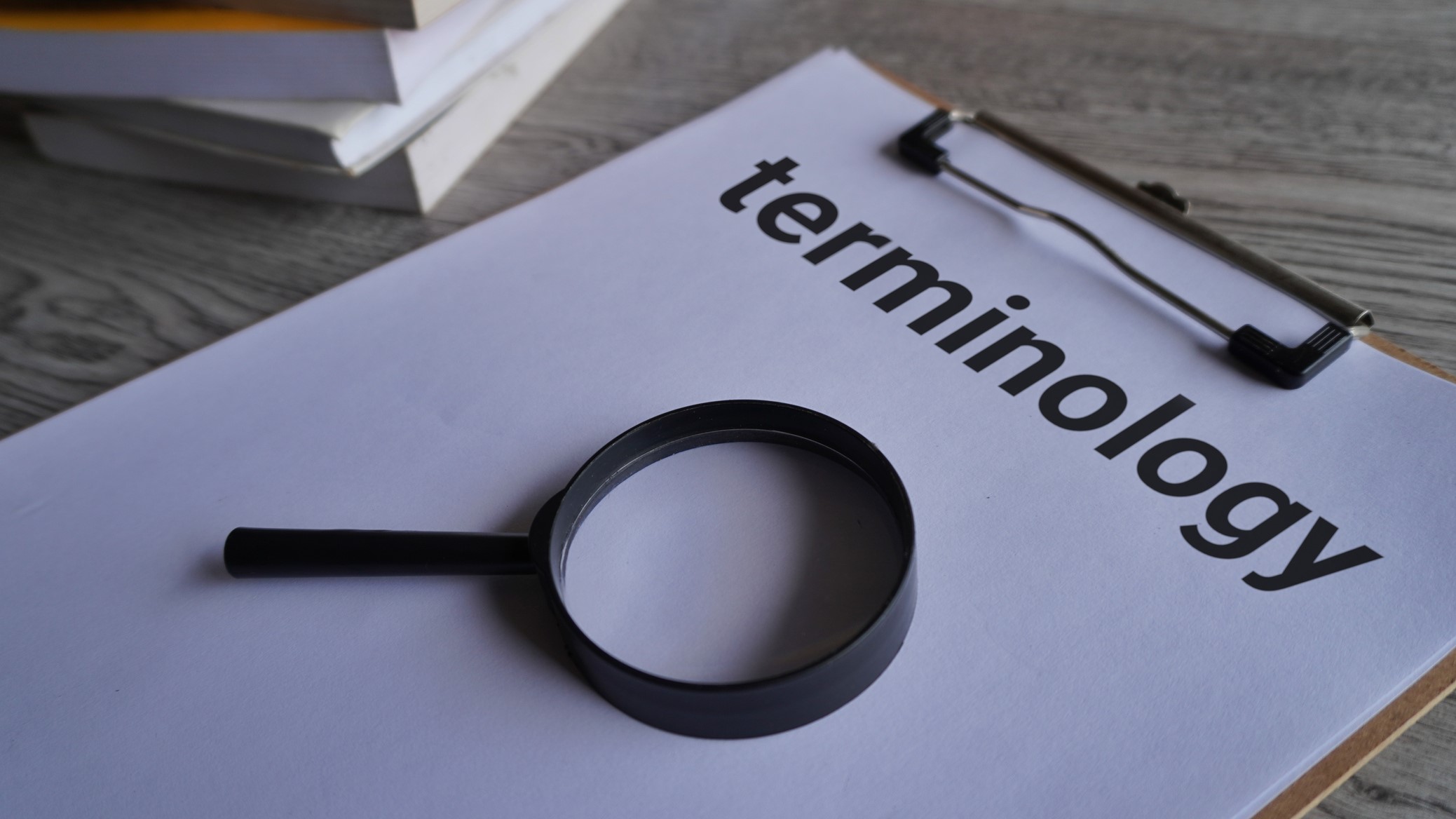 — title missing — Magnifying glass and clipboard with paper and the word "terminology"