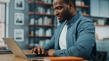 — title missing — Seated man using a laptop.