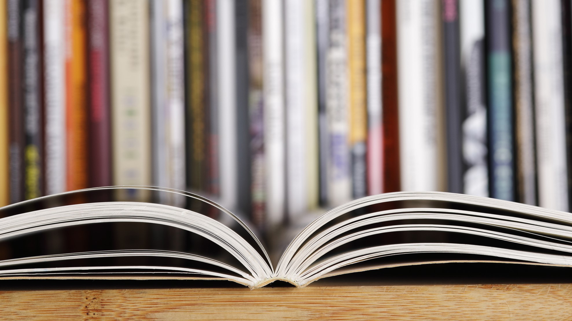 — title missing — An open scientific journal in the foreground with many journals standing in the background