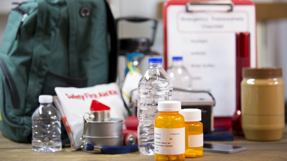 Emergency kit Emergency preparedness items, including a backpack, first aid kit, medications, and bottled water.