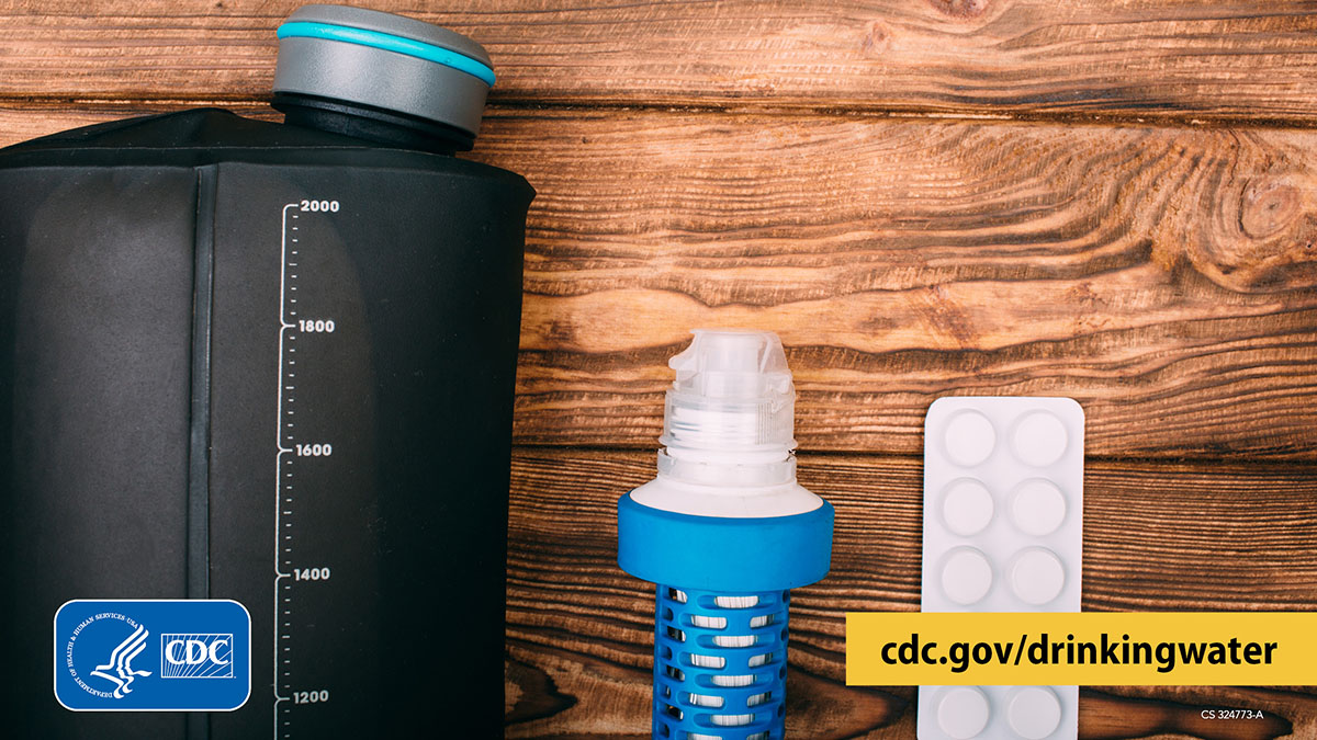 Water filter and disinfection tablets graphic 1200x675 Water container with volume markings, water filter cartridge, and water disinfectant tablets on a wooden surface.