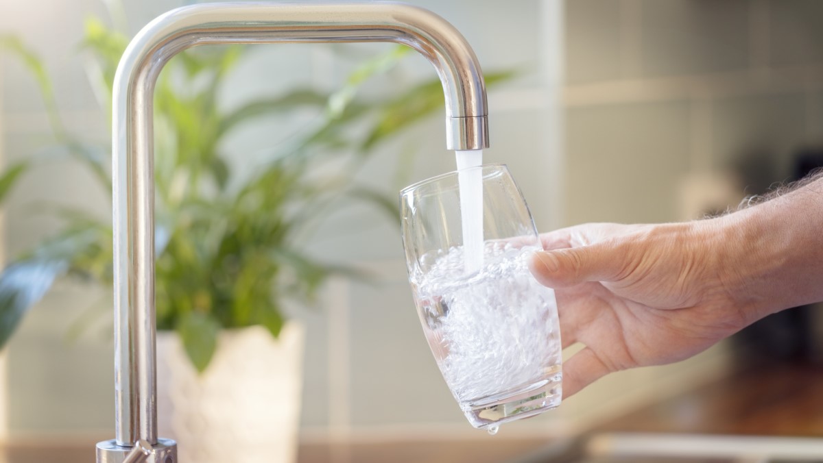 Filling glass with tap water Person filling a glass with tap water from the kitchen sink