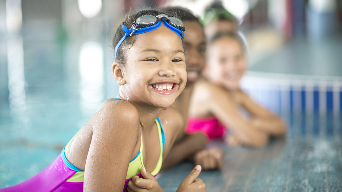 Young girl in swim lesson on pool edge