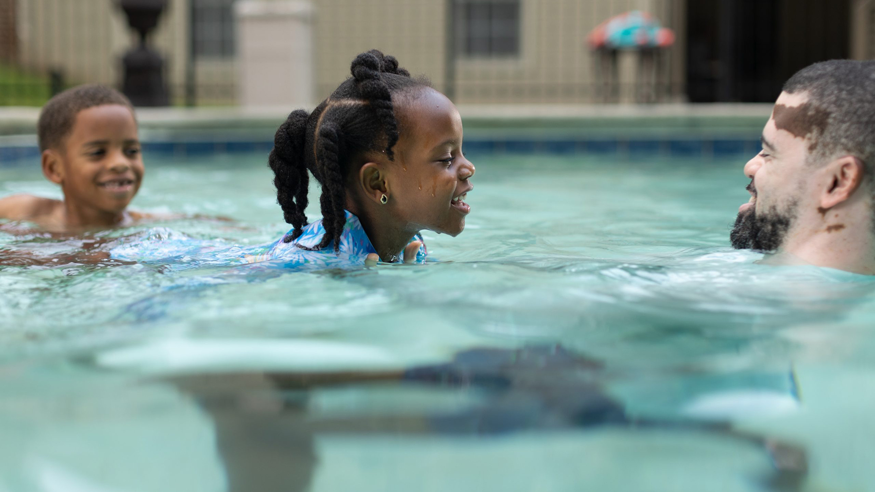 DP150PoolPlayBlackGirlDadBoy.jpg Two Black kids in pool with dad.