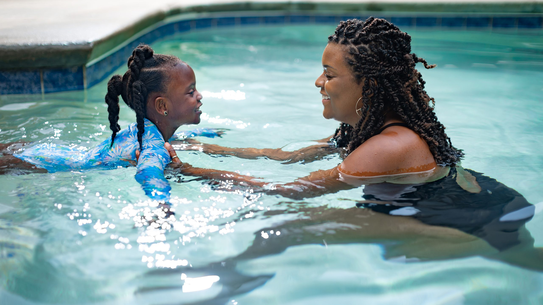 DP438SwimLessonPoolBlackGirlMom.jpg Swim lessons with Black mom and daughter in pool.