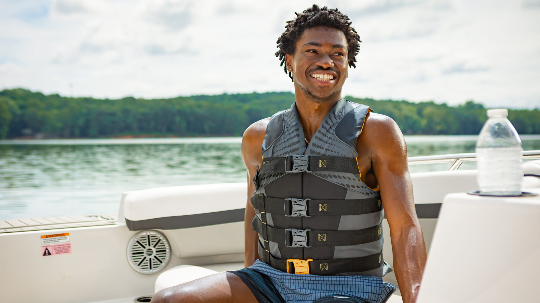 DP572LifeJacketOnBoatYoungBlackMale.jpg Young man on boat wearing a life jacket.