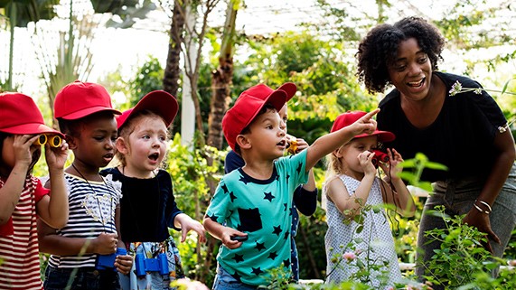 — title missing — Children in garden with their teacher.