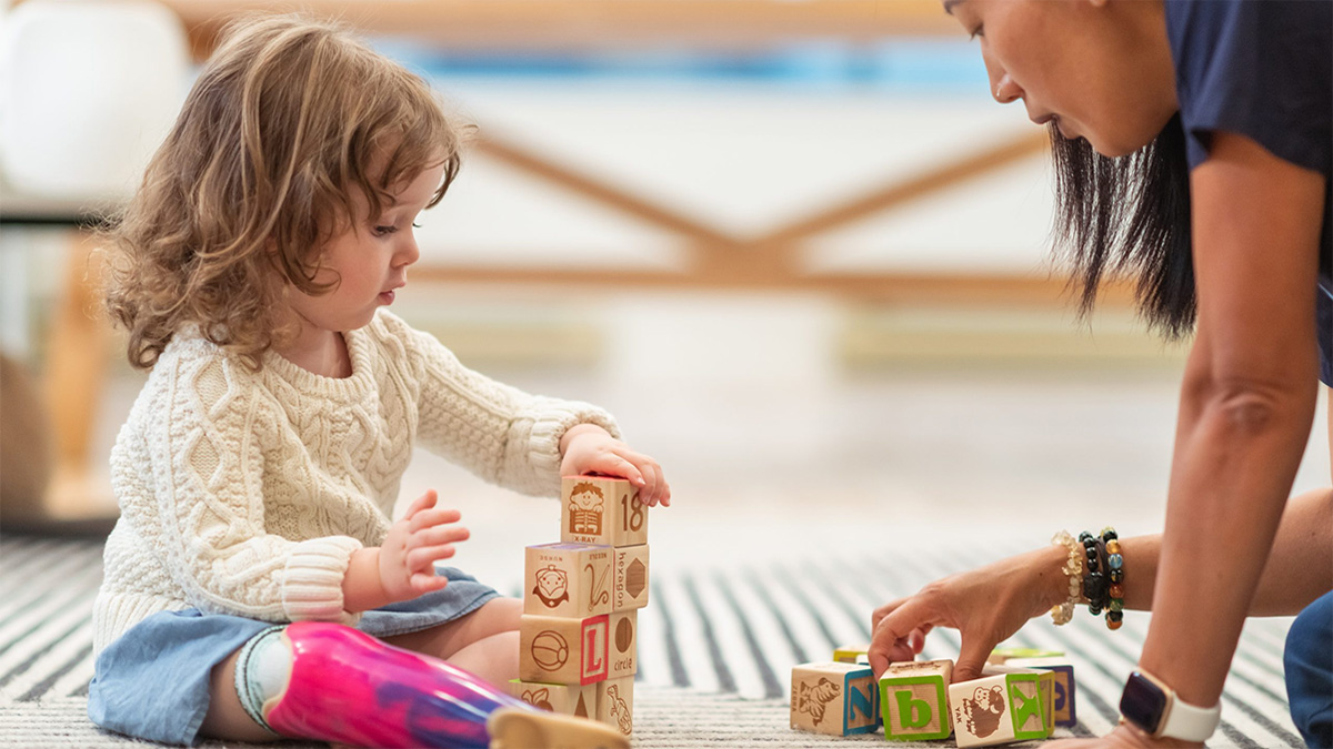 School teacher and young student School teacher and young student playing with blocks