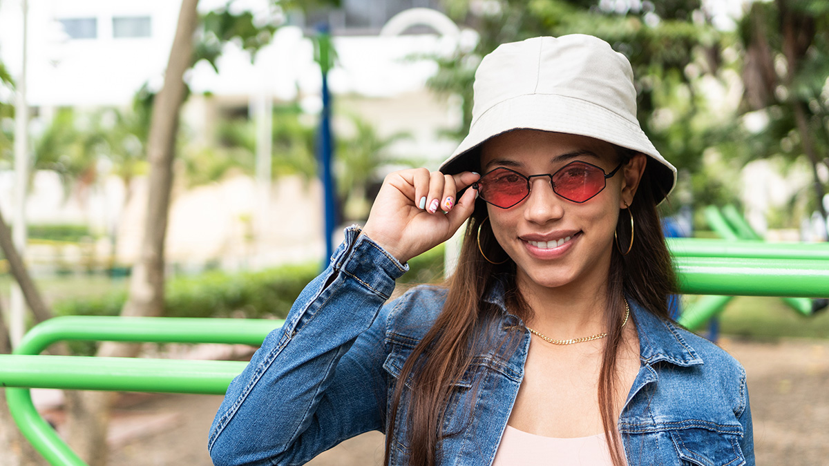 Young woman outdoors Young woman outdoors wearing hat, sunglasses, and long sleeves